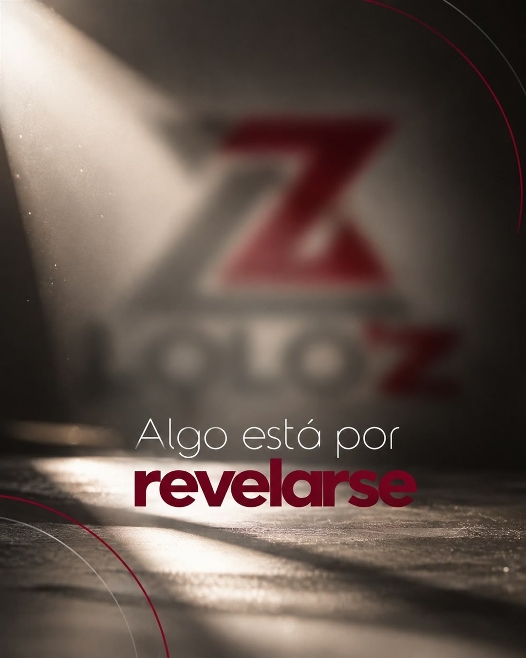 Logo de LOLO’z desenfocado bajo un haz de luz: Algo está por revelarse.